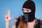 Woman in balaclava gun gesture, crime and violence