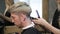 Woman barber maiking man\'s haircut