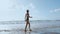 Woman bare foot walking on the summer beach. close up leg of young woman walking along wave of sea water and sand on the