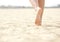 Woman barefoot walking on beach