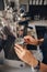 Woman barista hands holding milk jug for making coffee using coffee machine