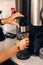 Woman barista hands making pouring coffee from coffee machine in plastic transparent cup