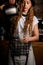 woman barista holds transparent glass and pours drink from coffee pot into it