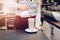 Woman barista pouring coffee to foamed milk.