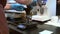 Woman barista pours ground coffee and weighs it while working in kitchen.