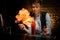 Woman bartender sets huge fire flame over glass with cocktail.