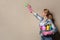 Woman with basin of detergents cleaning color wall