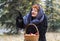 Woman with basket of apples in the forest, comes the first snow