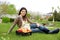 Woman with basket apples sitting on grass in garden