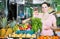 woman with basket with fresh greengrocery enjoying purchases in vegetable store