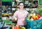 woman with basket with fresh greengrocery enjoying purchases in vegetable store