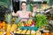 woman with basket with fresh greengrocery enjoying purchases in vegetable store