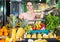 woman with basket with fresh greengrocery enjoying purchases in vegetable store