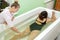 Woman in bath during hydromassage in beauty spa salon