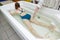 Woman in bath during hydromassage in beauty spa salon