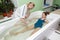 Woman in bath during hydromassage in beauty spa salon