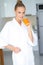 Woman in bath robe drinking orange juice