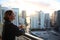 Woman in bathrobe drinking Her morning coffee or tea on a downtown balcony. beautiful sunrise in downtown Miami. Woman enjoying Mi