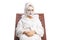 Woman in a bathrobe and hair wrapped in towel with a face mask resting on a lounge spa chair