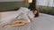 Woman in Bathrobe Lying on Fresh Bed in Hotel and Touching White Bed Sheets