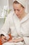 Woman in bathrobe painting nails