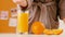 Woman bathrobe squeezing orange glass breakfast