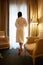 Woman in bathrobe stay near the window in hotel room