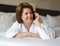 Woman in bathrobe talking on phone in hotel room