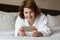 A woman in bathrobe wears telephone in hotel room