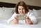 A woman in bathrobe wears telephone in hotel room