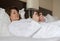 A woman in bathrobe wears telephone in hotel room