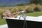Woman In Bathtub With Champagne On Countryside Porch