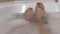 Woman in bathtub moving feet in water