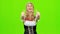 Woman in bavarian national costume laughs and shows thumb. Green screen