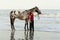 Woman on beach with appaloosa