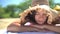 Woman beach beauty portrait video. Lady lying down tanning wearing straw hat as sun protection on beach holiday. Summer