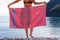 Woman on beach covering hips with towel