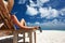 Woman at beach holding sunglasses