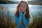 Woman at the Beach by the Lake in Fall Clothing. Young woman spending time by the lake in autumn