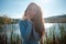 Woman at the Beach by the Lake in Fall Clothing. Young woman spending time by the lake in autumn