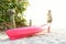 Woman on beach with pink kayak