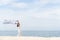 Woman on the beach, portrait of young happy woman wearing white dress and holding scraft on tropical sand beach. Summer Concept