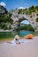 Woman on the beach by the river in the Ardeche France Pont d Arc, Ardeche France,view of Narural arch in Vallon Pont D