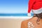 Woman on the beach in santas hat