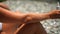 Woman beach sea. Women's legs by the sea and women's hands are smeared with sunscreen. Slow motion video of a