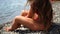 Woman beach sea. Women's legs by the sea and women's hands are smeared with sunscreen. Slow motion video of a