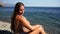 Woman beach sea. Women's legs by the sea and women's hands are smeared with sunscreen. Slow motion video of a