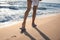 Woman in beach slippers walking on sandy seashore, closeup