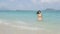 Woman at beach walking out of sea in bikini