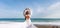 Woman beach white dress flying on Wind. Summer Vacation. A happy woman takes vacation photos to send to friends.